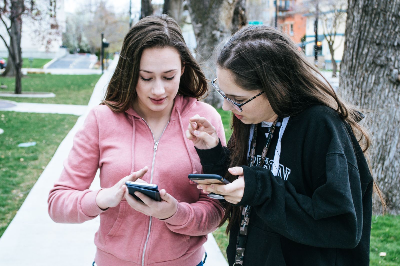 Deux personnes regardent leur téléphone en plein air