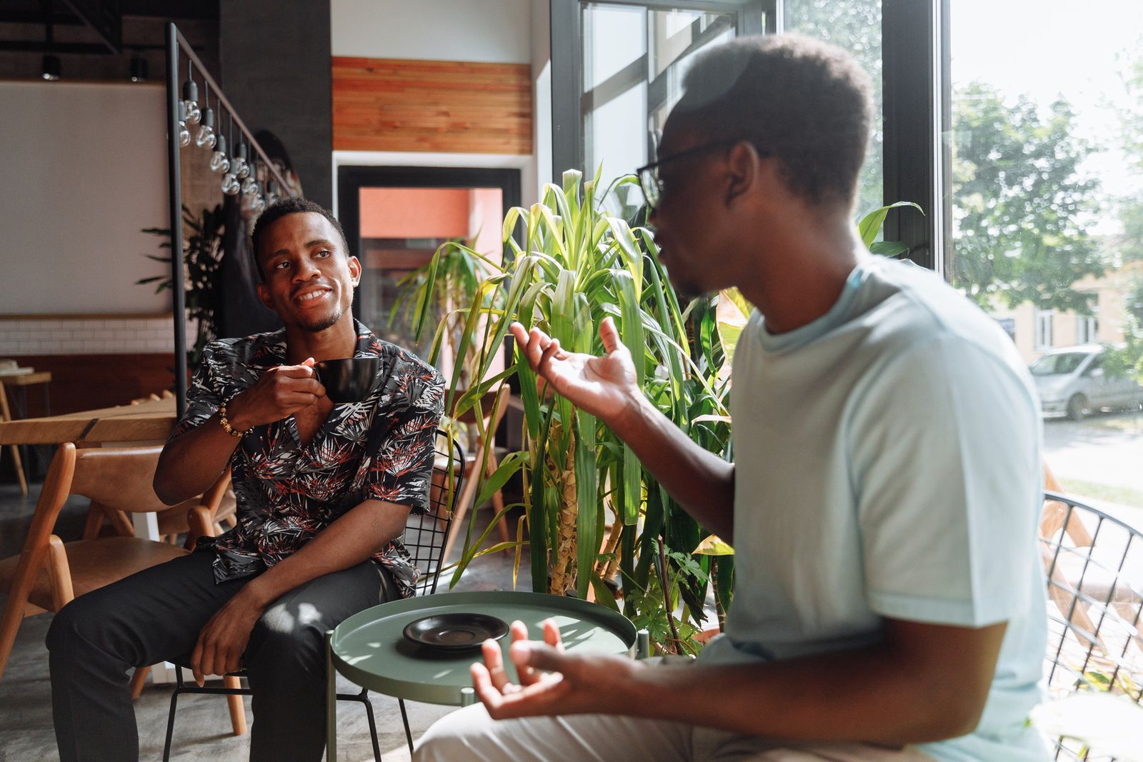 Dos personas charlan sonrientes en la terraza de un café