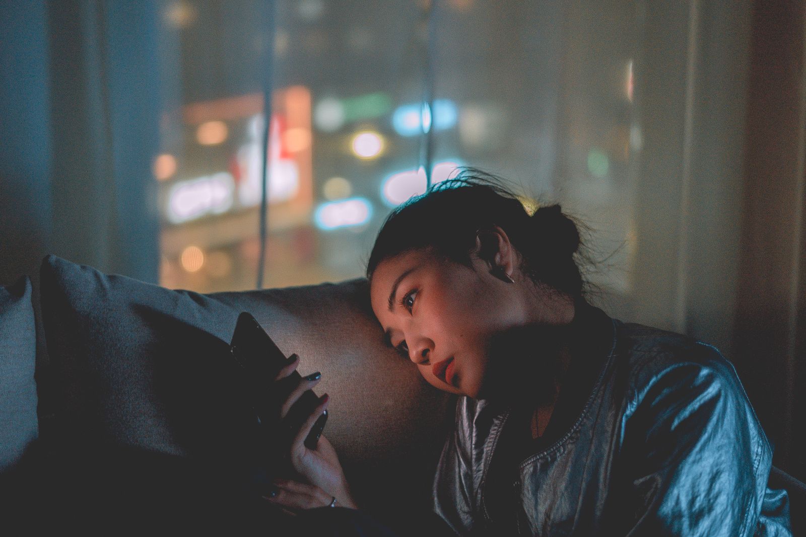 Una persona mira su teléfono, sola, por la noche